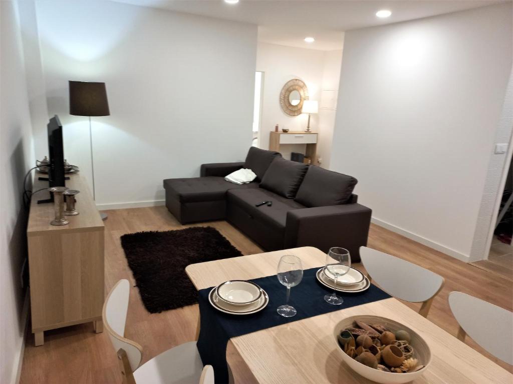 una sala de estar con una mesa y un sofá en Ares do Mar - 4 beds apartment and car parking, en Matosinhos