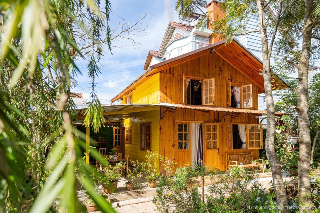 a wooden house with an open window and trees at Gỗ Thông Lâm Viên Villa Đà Lạt in Da Lat