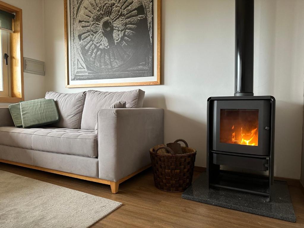 a living room with a couch and a wood stove at Casas de Alpedrinha in Alpedrinha