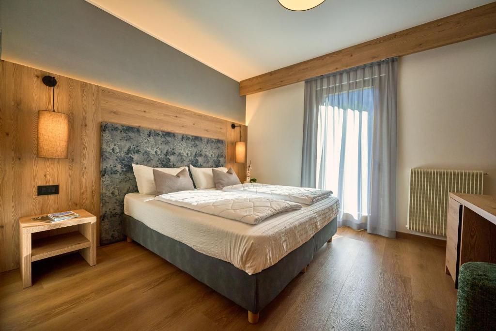 una camera da letto con un letto e una grande finestra di Hotel Rio a Caderzone