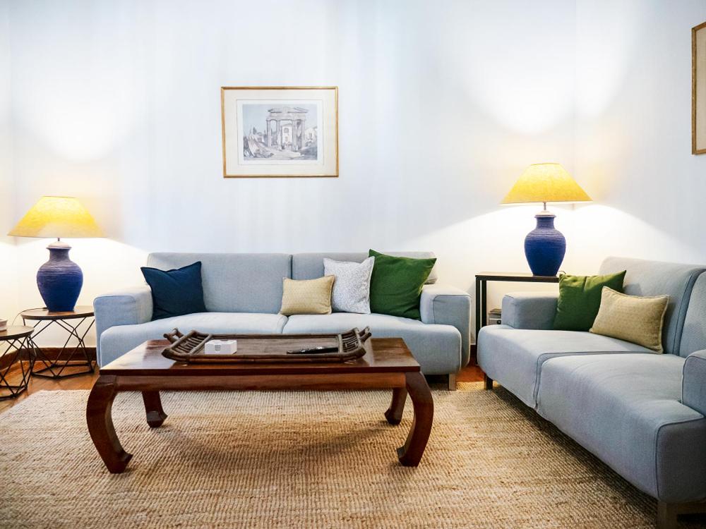 ein Wohnzimmer mit 2 blauen Sofas und einem Couchtisch in der Unterkunft The Arcade in Athen