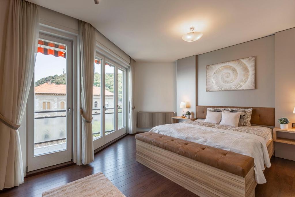 a bedroom with a large bed and large windows at Luxury Residence with a Beautiful view for the Danube River in Budapest
