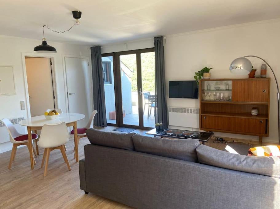 ein Wohnzimmer mit einem Sofa und einem Tisch in der Unterkunft Les 3 Frères : plain-pied en pleine nature in Vresse-sur-Semois