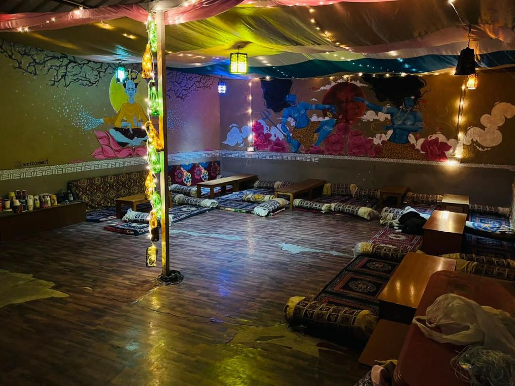 a party room with a stage with lights and a dance floor at Reverberate Cafe & Cottages - Negi's Place in Jibhi