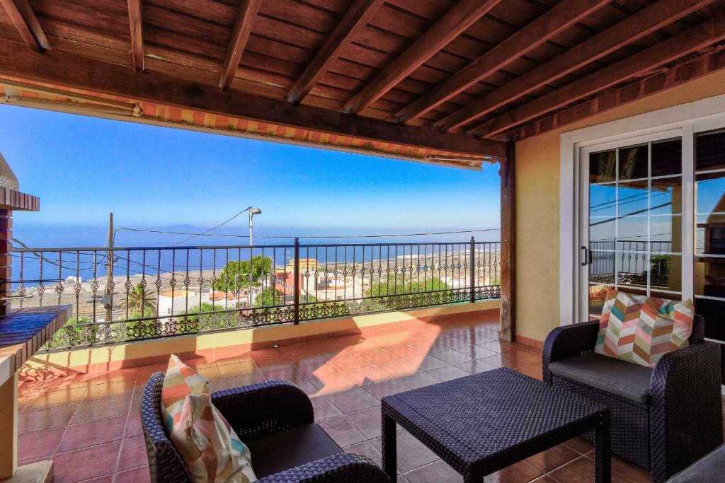 a room with a balcony with a view of the ocean at Casa Rural Tijoco Bajo Con Jacuzzi Adeje in Adeje