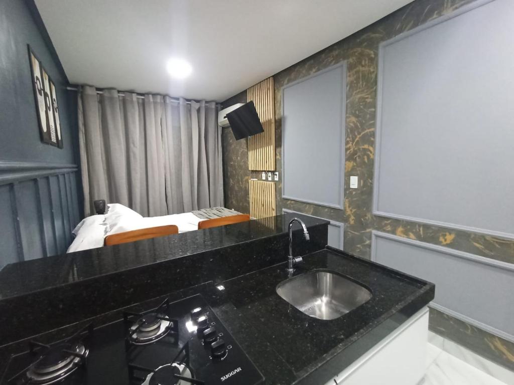 una cocina con fregadero y una cama en una habitación en FLAT - 200m da orla do Bessa, en João Pessoa