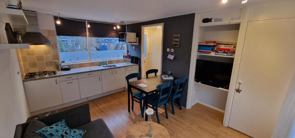 a kitchen with a table and chairs in a room at Ferienhaus Abenteuer in Egmond aan Zee