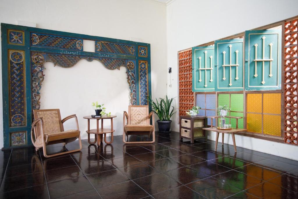 una habitación con sillas y mesas en una habitación en Rumah Kalpataru, en Yogyakarta
