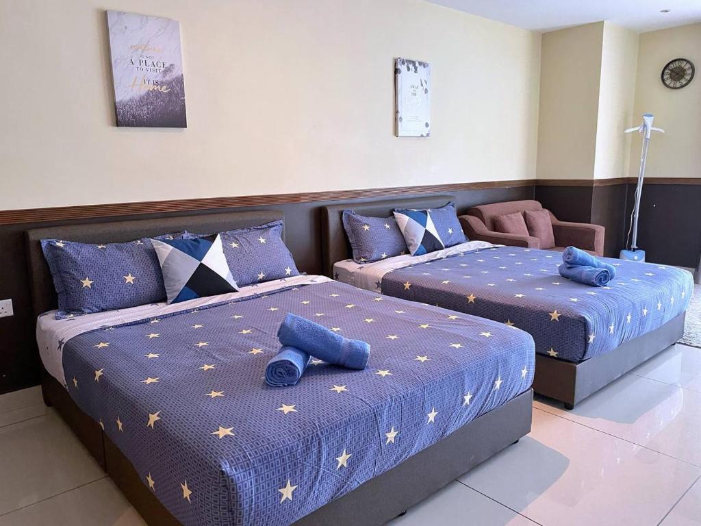two beds in a room with blue pillows on them at KSL D'Esplanade Apartment Suites by SC Homestay in Johor Bahru