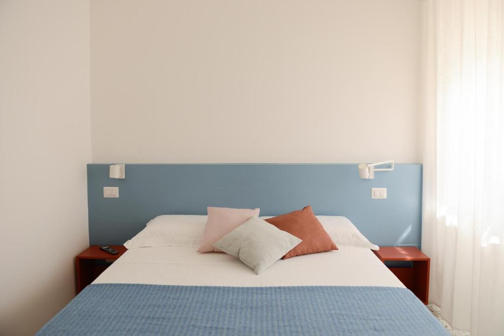 1 dormitorio con 1 cama grande y cabecero azul en La Rosa rooms & holiday home, en Porto SantʼElpidio