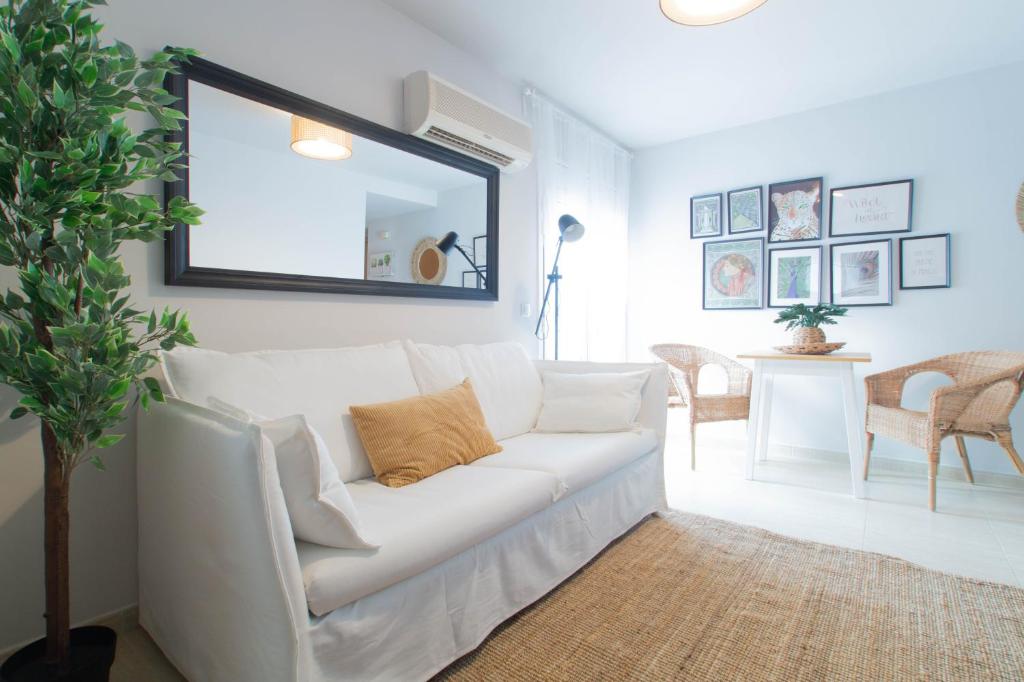 sala de estar con sofá blanco y espejo en Budget Beach Studio 22, en Sant Antoni de Calonge