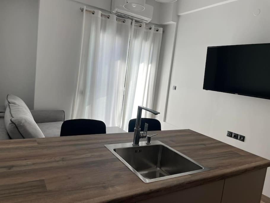 a kitchen counter with a sink and a flat screen tv at October Luxury Apartments in Ioannina