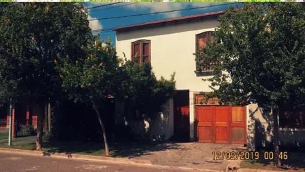 Casa blanca con garaje rojo en Amplia casa con parque y pileta en Olavarría
