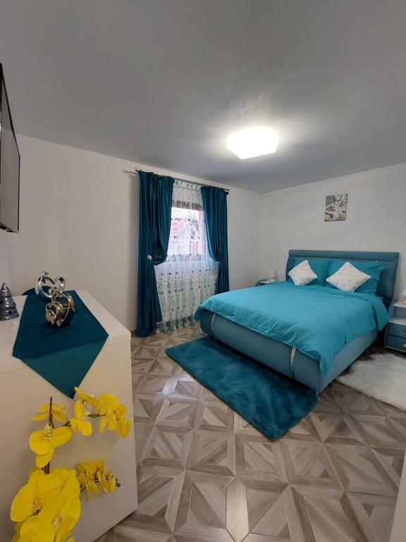 ein Schlafzimmer mit einem blauen Bett und einem Fenster in der Unterkunft Maria's Dream House in Zărneşti