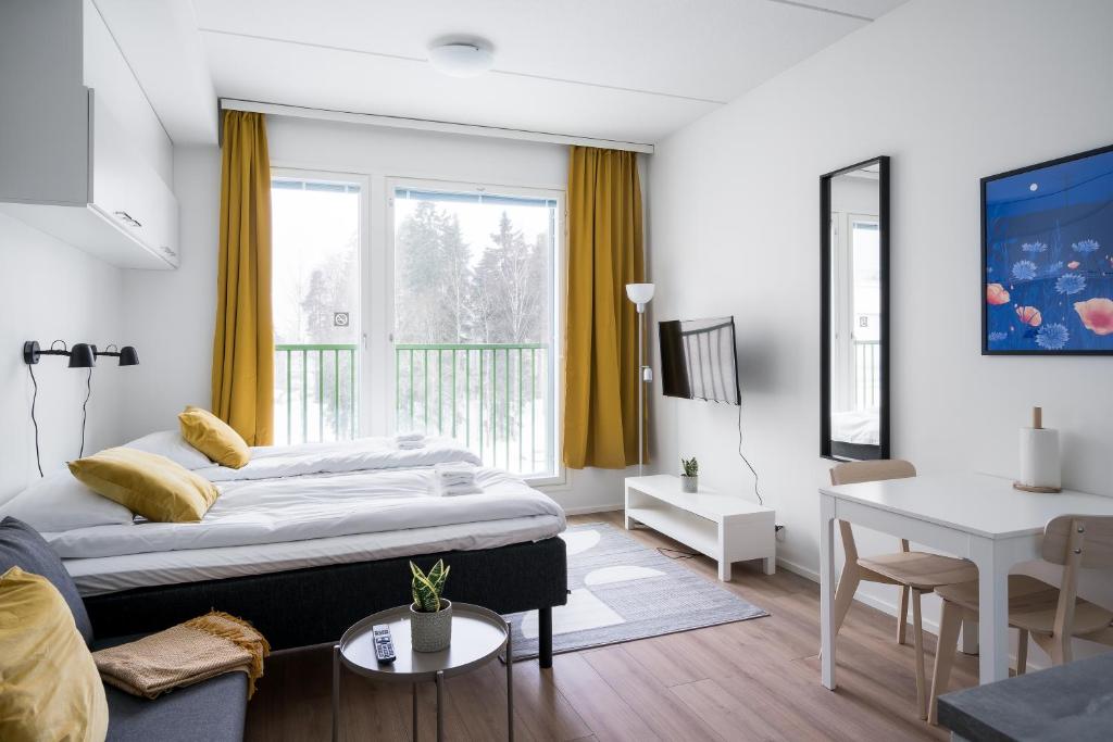 um quarto com uma cama e uma sala de estar em Hiisi Homes Järvenpää em Järvenpää