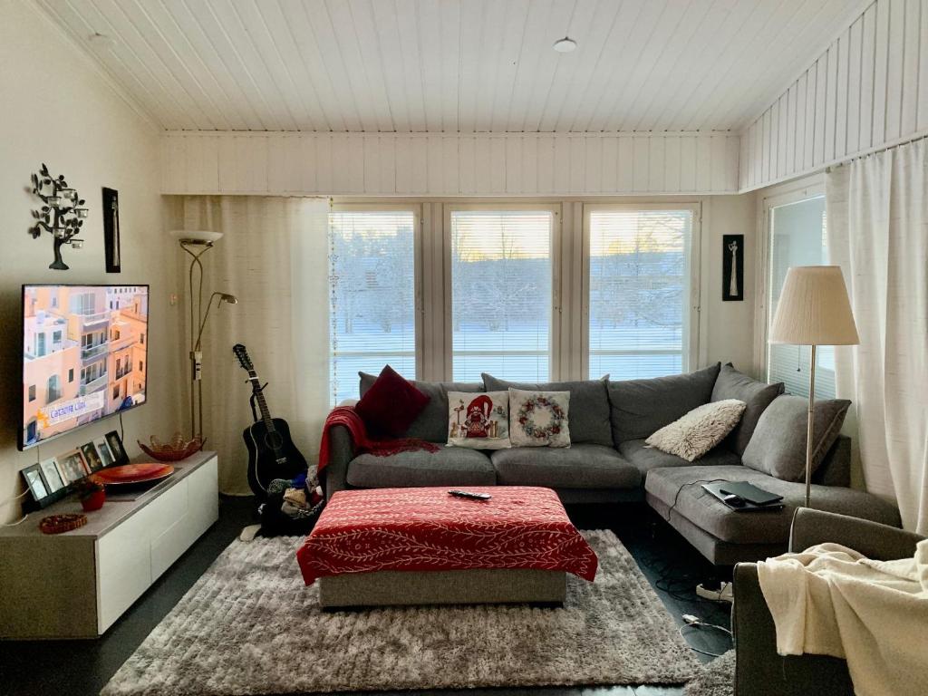 a living room with a couch and a tv at Riverside Home for families - beautiful house near Santa Claus Village in Rovaniemi
