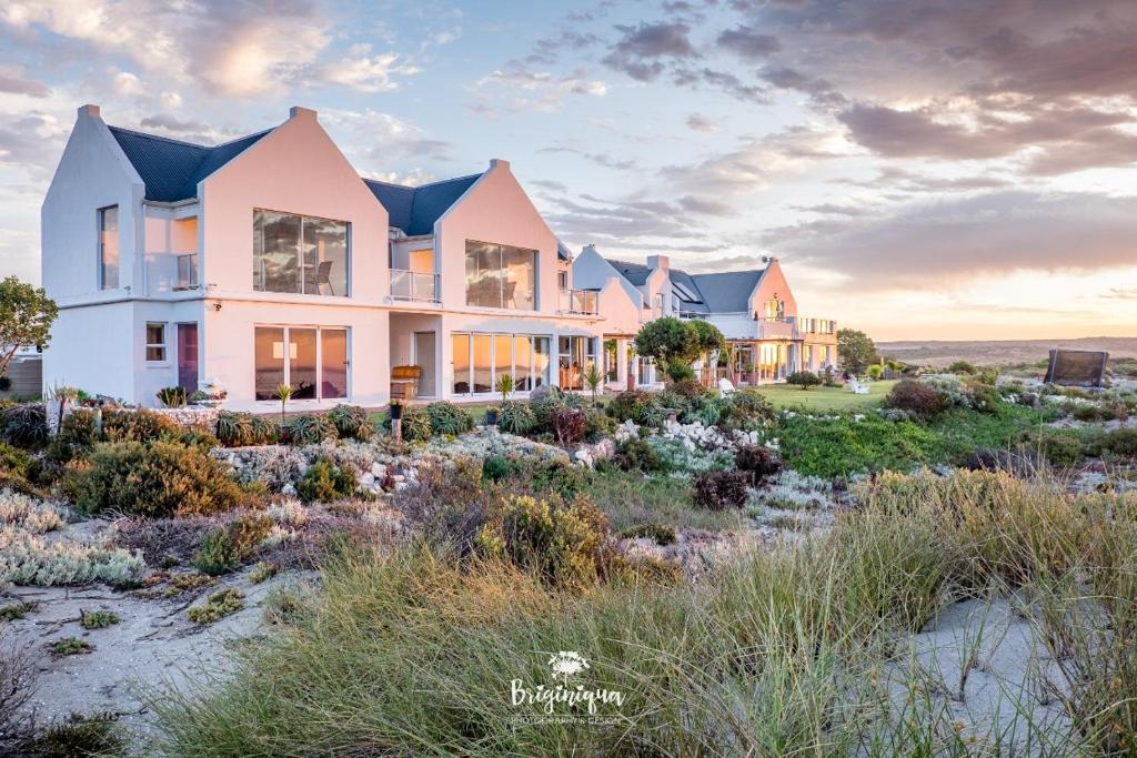 una casa en la playa con el océano en el fondo en Sandspoor, en St Helena Bay