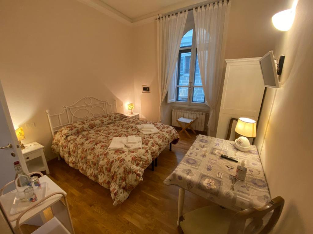 1 dormitorio con cama, mesa y ventana en Relais Del Duomo, en Florencia