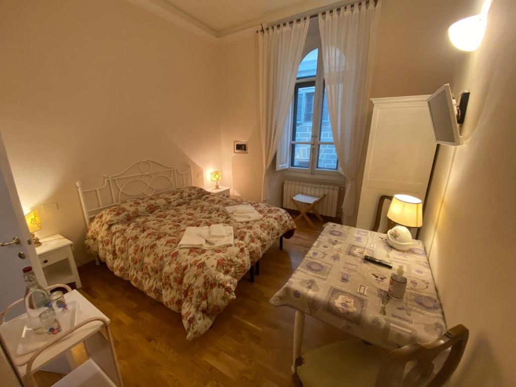 a bedroom with a bed and a table and a window at Relais Del Duomo in Florence