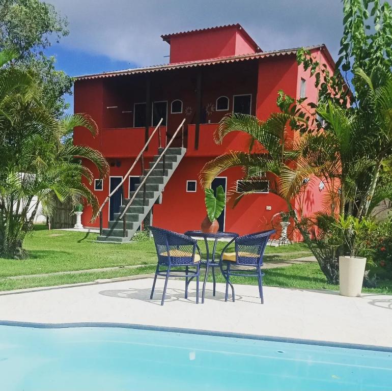 ブジオスにあるPousada Arpoador de Búziosのプールサイドのテーブルと椅子付きの家