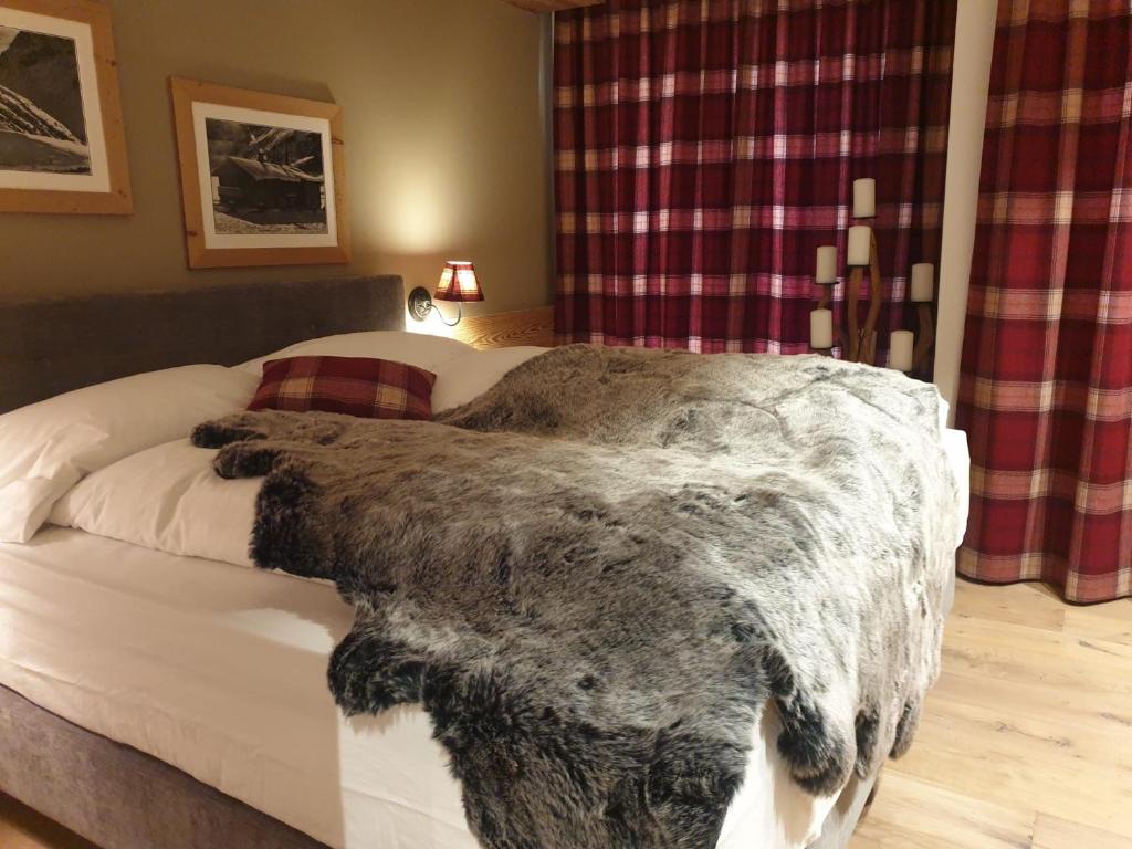 - une chambre avec un lit et une couverture dans l'établissement Davos, Residenz Meierhof, Chasa Hubertus, à Davos