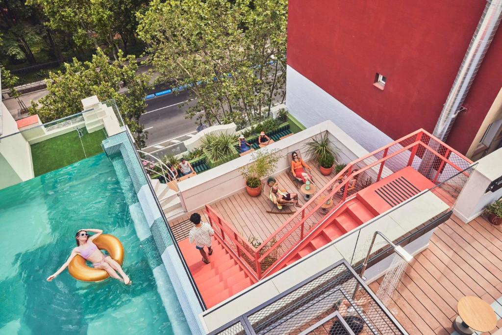 una vista aérea de una piscina con una chica en una balsa en The Social Hub Madrid, en Madrid