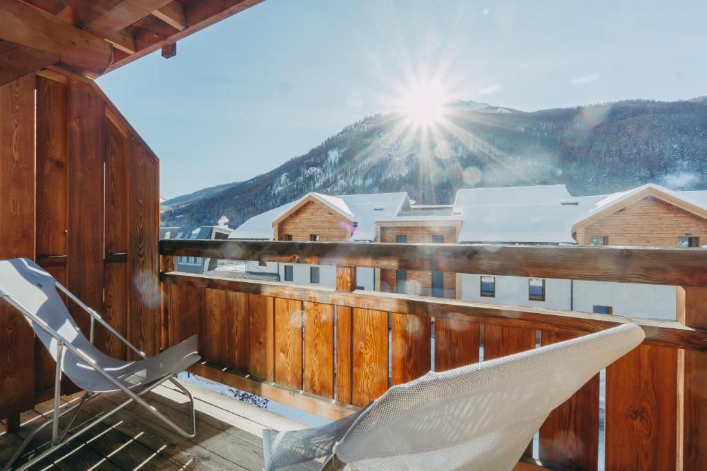 een stoel op een balkon met de zon op de achtergrond bij Résidence Le Chalet de L'Eterlou by Popinns in Saint-Chaffrey