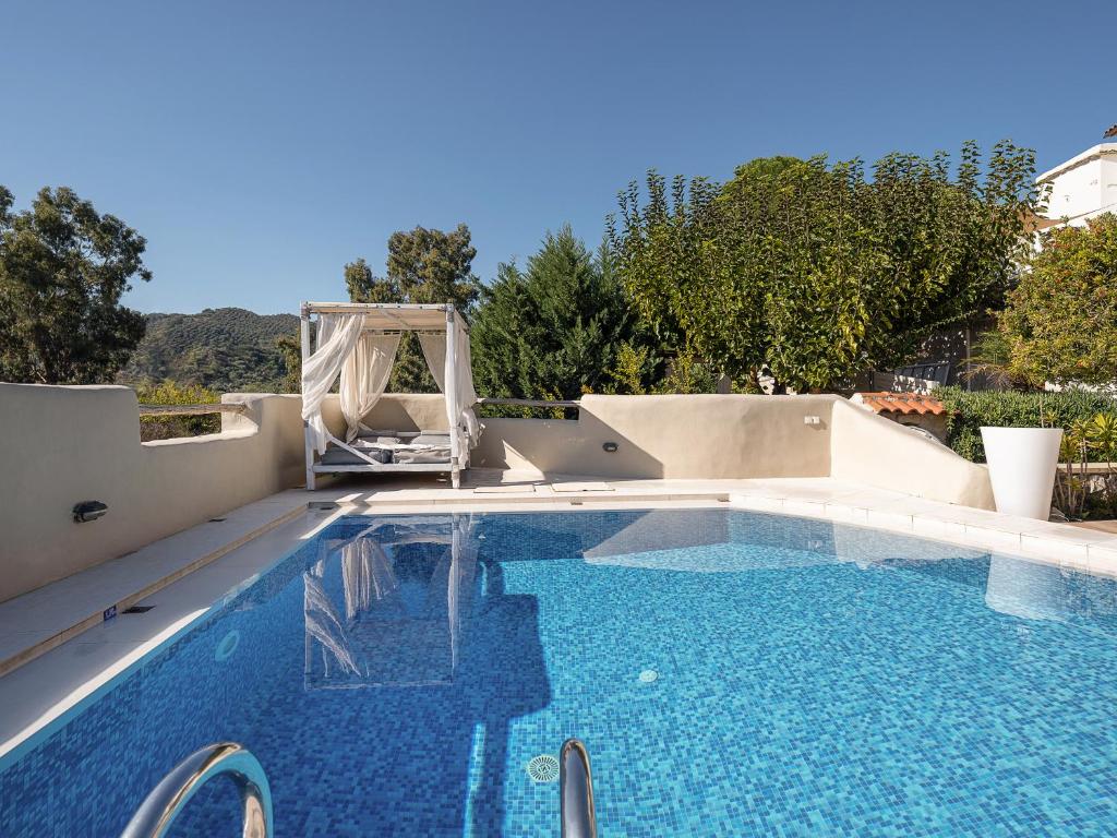 una piscina con una silla y una piscina en Verekinthos Villa, a Fine Country Retreat, By ThinkVilla, en Yerolákkos