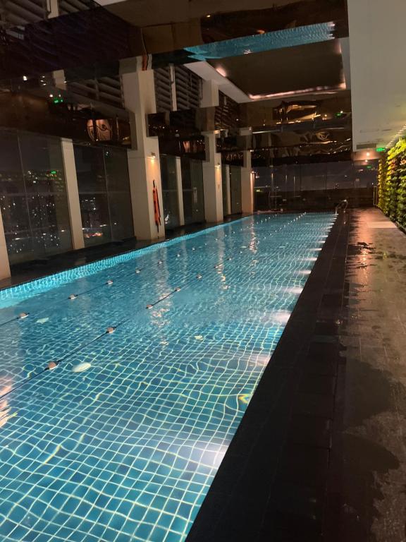 a large swimming pool with blue tiles in a building at Spacious Loft in Gramercy in Manila