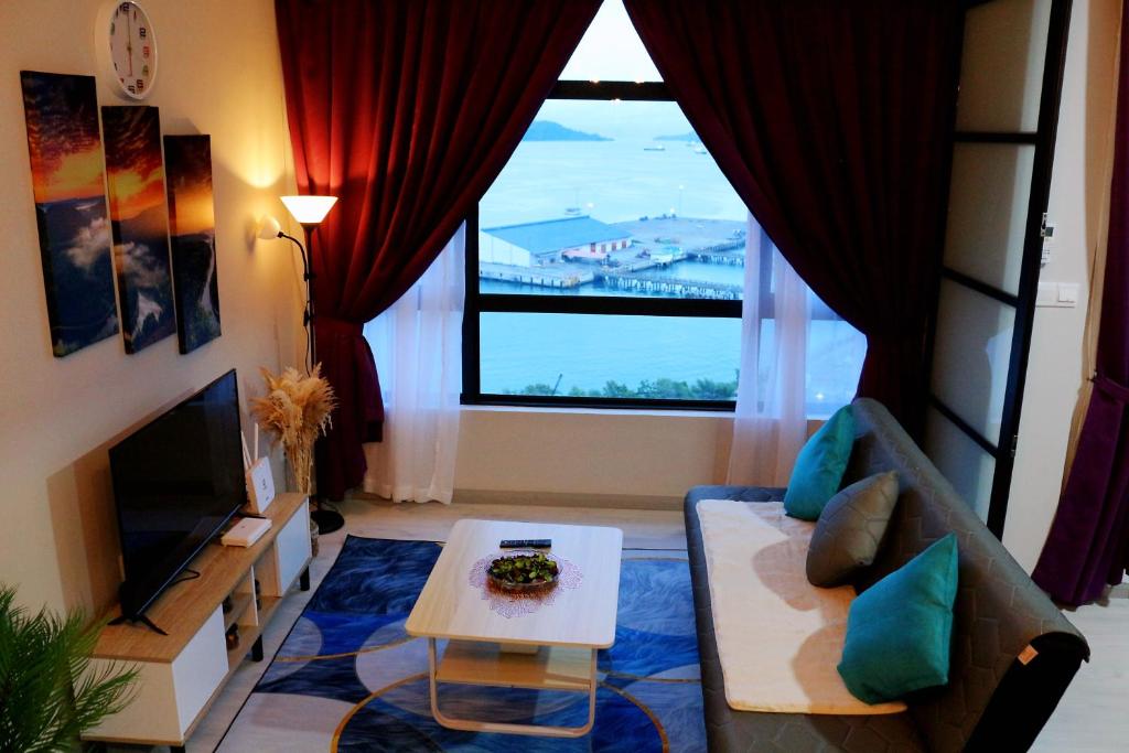 sala de estar con sofá y ventana grande en MLH Designer Suites @ Jesselton Quay CityPads en Kota Kinabalu