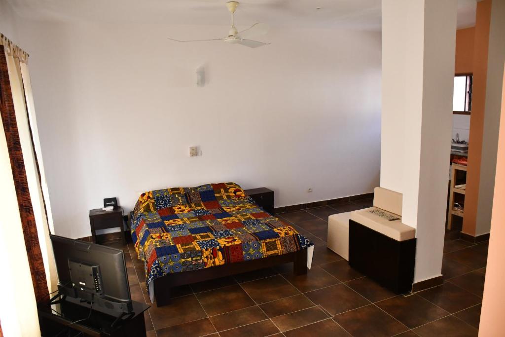 um quarto com uma cama e uma televisão em Studio Assiba 1 em Cotonou