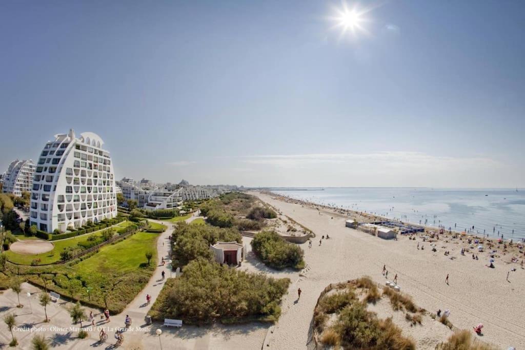 widok na plażę z budynkiem i ocean w obiekcie PGH N6 - 100m de la Plage, Terrasse, Parking w mieście La Grande-Motte