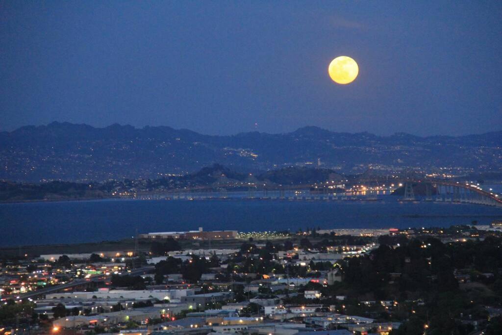 een volle maan die 's nachts boven een stad opkomt bij Farm in the city with sweeping bay view in San Rafael