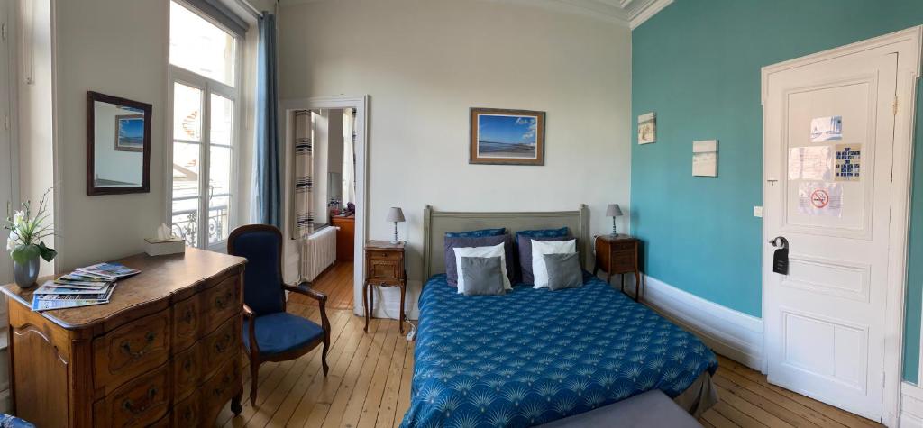 a bedroom with a blue bed and a wooden desk at Chambres d'Hôtes Au coin du spa in Boulogne-sur-Mer