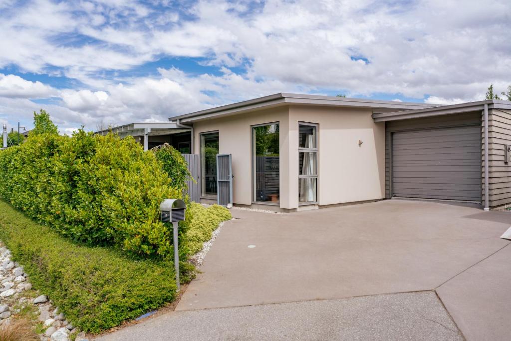 a house with a garage and a parking meter at Urban Oasis - Wanaka Holiday Home in Wanaka