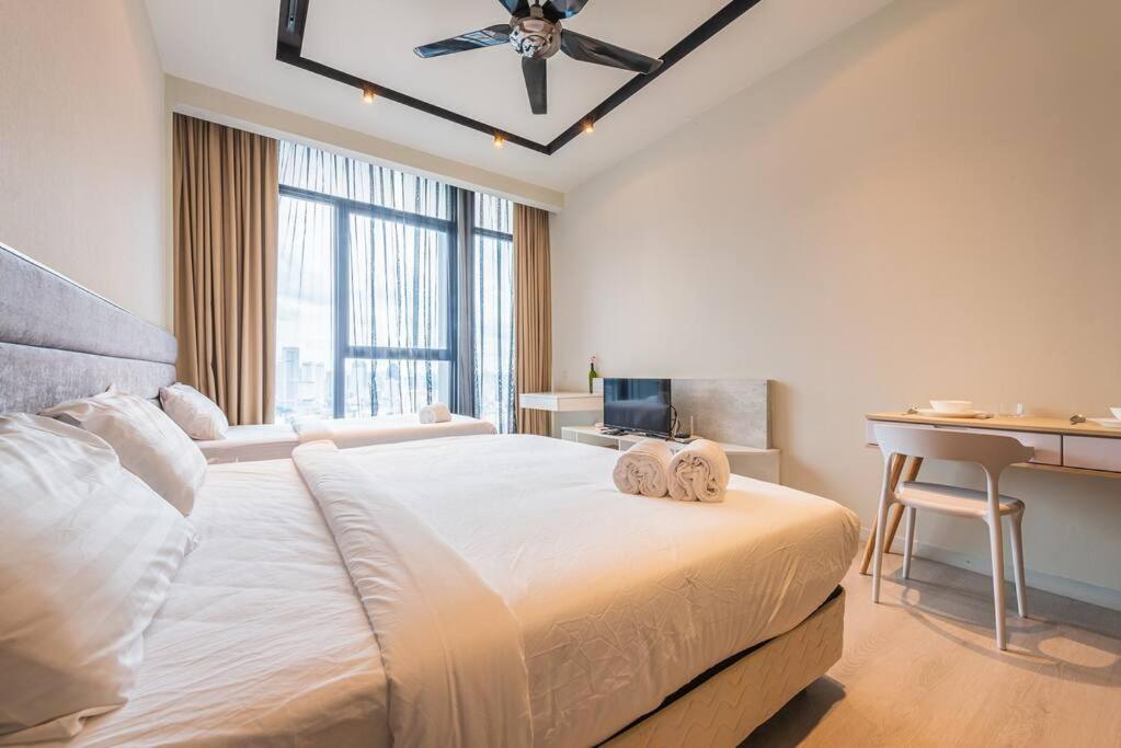 a bedroom with a bed with a desk and a ceiling fan at ExpressionZ Suites KLCC by EC in Kuala Lumpur