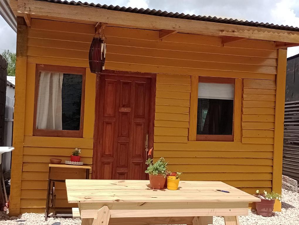 um barracão amarelo com uma mesa à frente em Cabaña en Tigre em Tigre