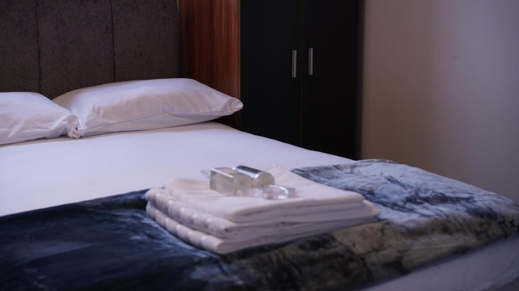 a pile of towels sitting on top of a bed at Reach Guest House in Birmingham