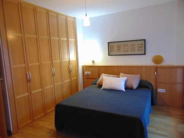 - une chambre avec un lit et quelques placards en bois dans l'établissement Chalet las Planas Tramacastilla, à Tramacastilla de Tena
