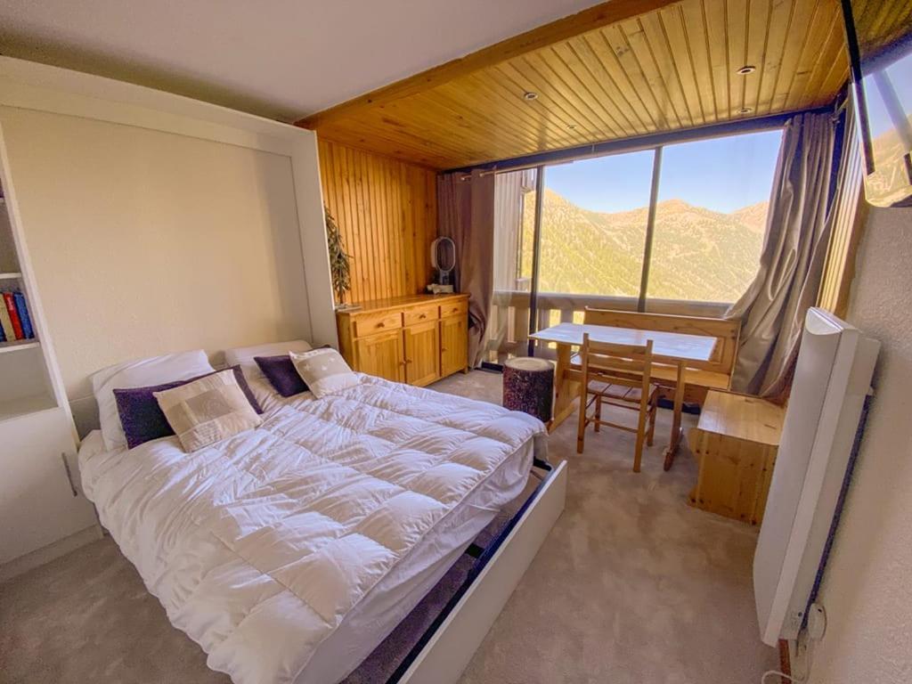 um quarto com uma cama, uma mesa e uma janela em Exclusivité, 6Pers, Sauna, wifi, local à ski em Isola 2000