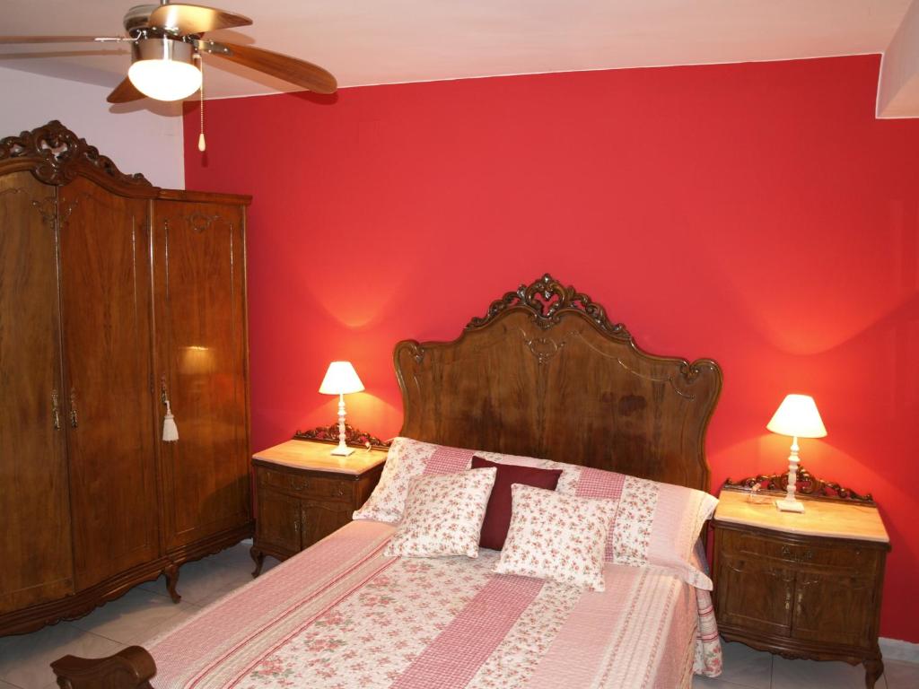 a bedroom with a bed with a red wall at Casa Piquero in Sieste