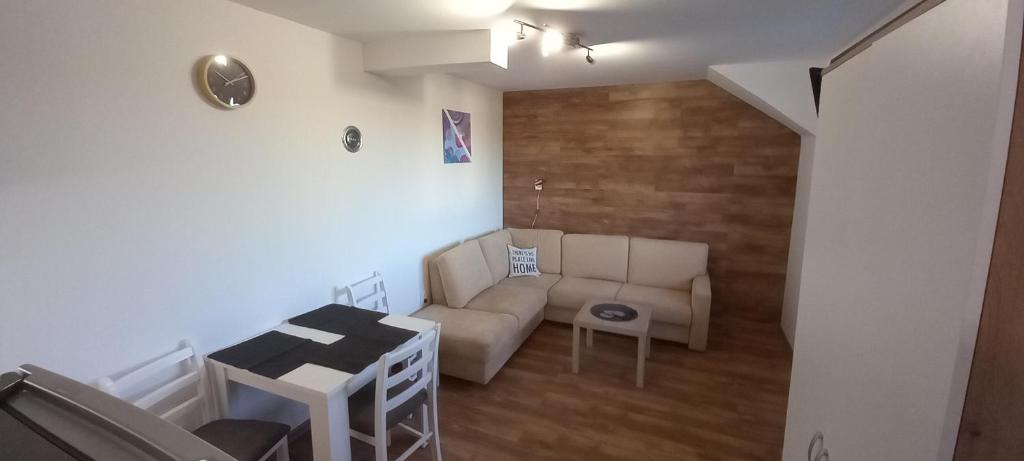 ein Wohnzimmer mit einem Sofa und einem Tisch in der Unterkunft Apartman Narcis Polje 3 in Divčibare