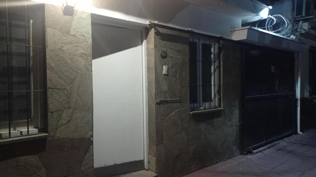 una puerta a un edificio con una pared de piedra en Casa Facu en Godoy Cruz