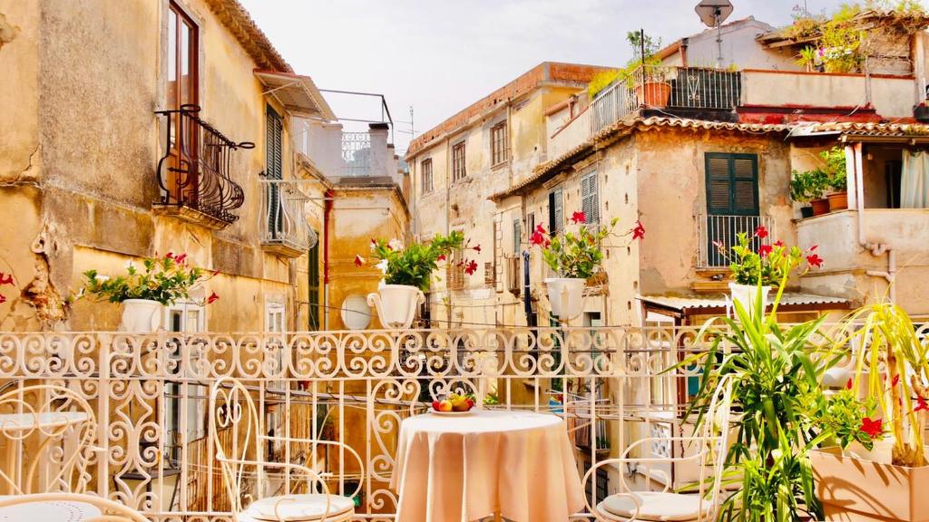 an alley with a table and chairs on a balcony at Le Due Sicilie in Tropea