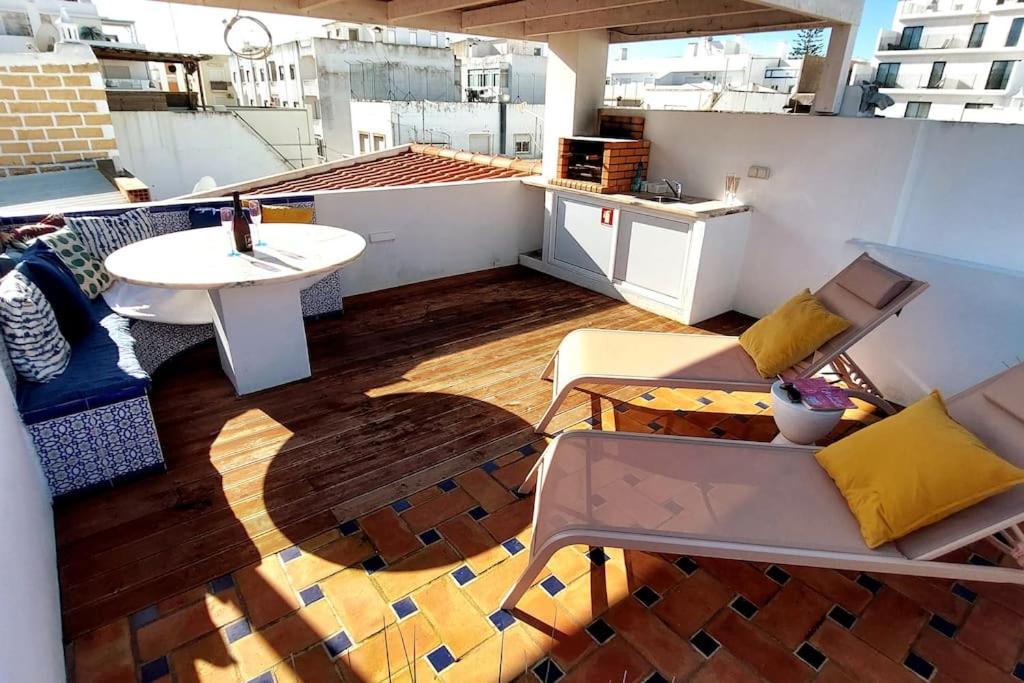 a balcony with a table and chairs on a roof at No. 7 Olhão in Olhão