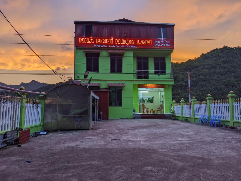 a green building with a sign on top of it at nhà nghỉ Ngọc Lam in Quang Ba