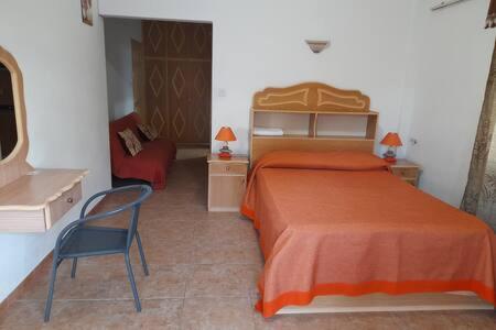 a bedroom with a orange bed and a chair at Dodo Villa in Pointe aux Biches