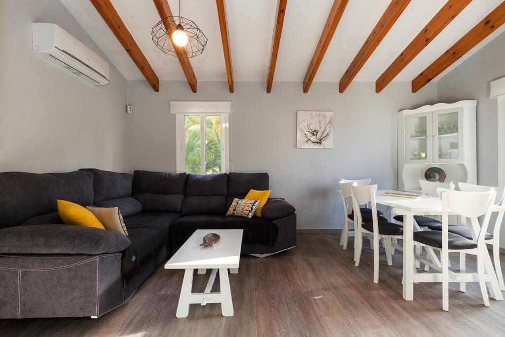 ein Wohnzimmer mit einem Sofa und einem Tisch in der Unterkunft Casa Sol del Sur 4 in Son Xoriguer