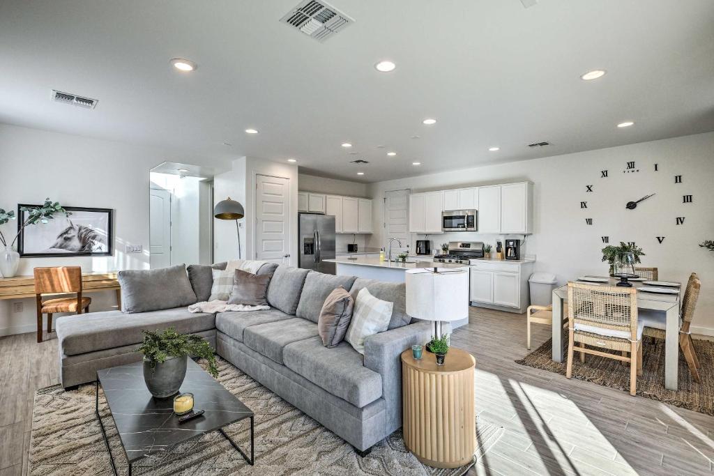 a living room with a gray couch and a kitchen at Mesa Vacation Rental with Community Pool Access in Queen Creek