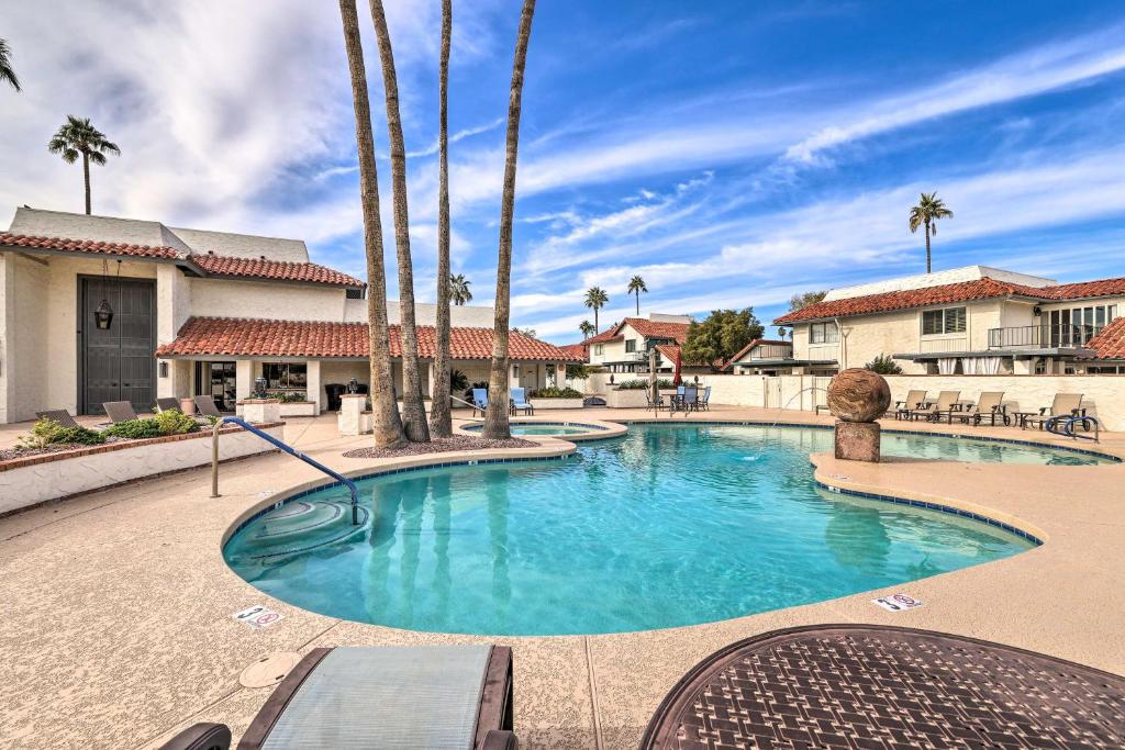 a swimming pool with palm trees in a resort at Central Scottsdale Townhouse with Pool Access! in Scottsdale